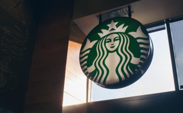 Starbucks logo sign inside a Starbucks cafe.