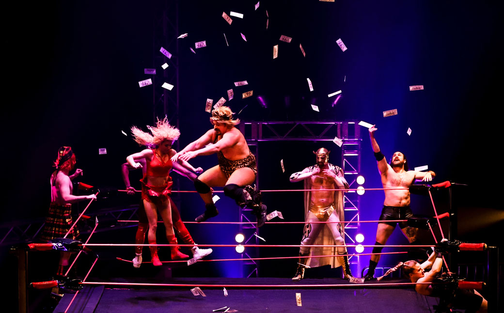 performers in a wrestling ring on a stage