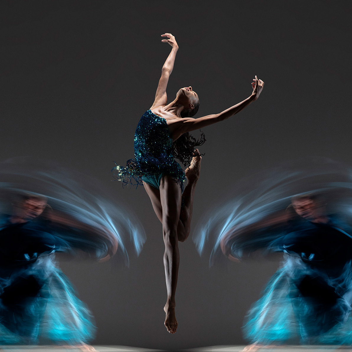 ballet performer in a blue leo doing a jump