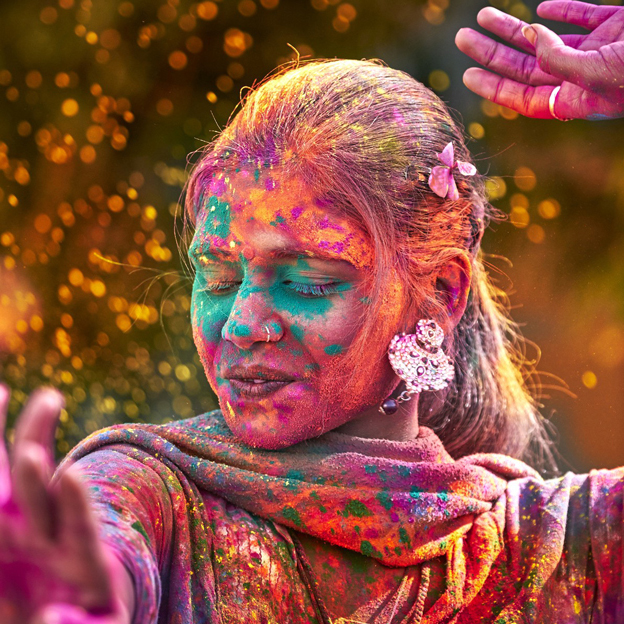 indian woman dancing covered in colored paint