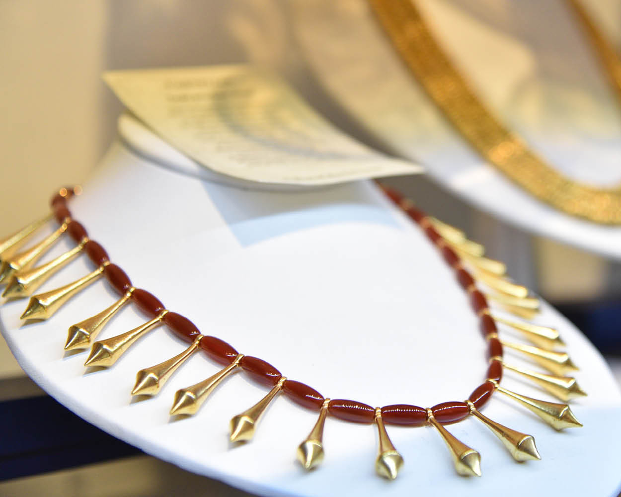 red and gold necklace on a display