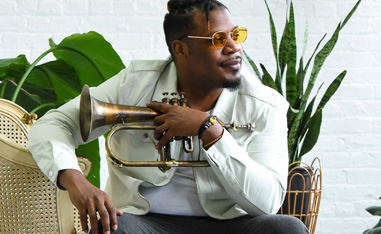 african american sitting in a chair with a trumpet in his hands