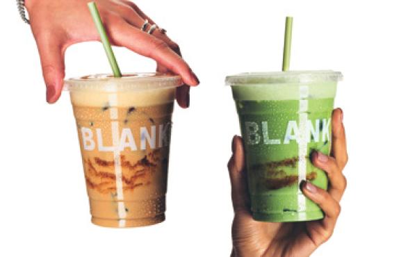 two hands holding an iced coffee and a macha in front of a white background