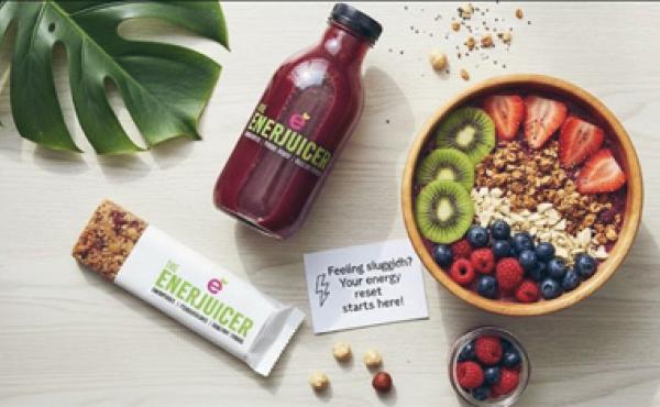 bottled juice and acai bowl on a table shot from above