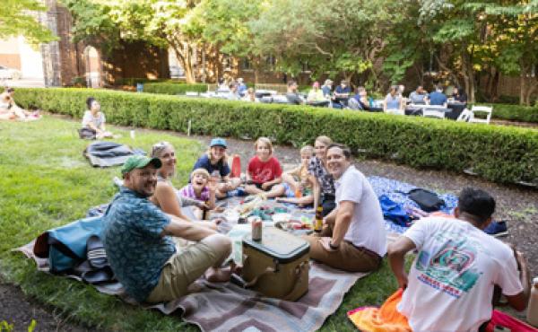 a family sitting on a blanket picnicing