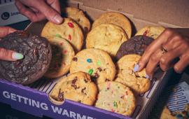 box of cookies with hands reaching for some